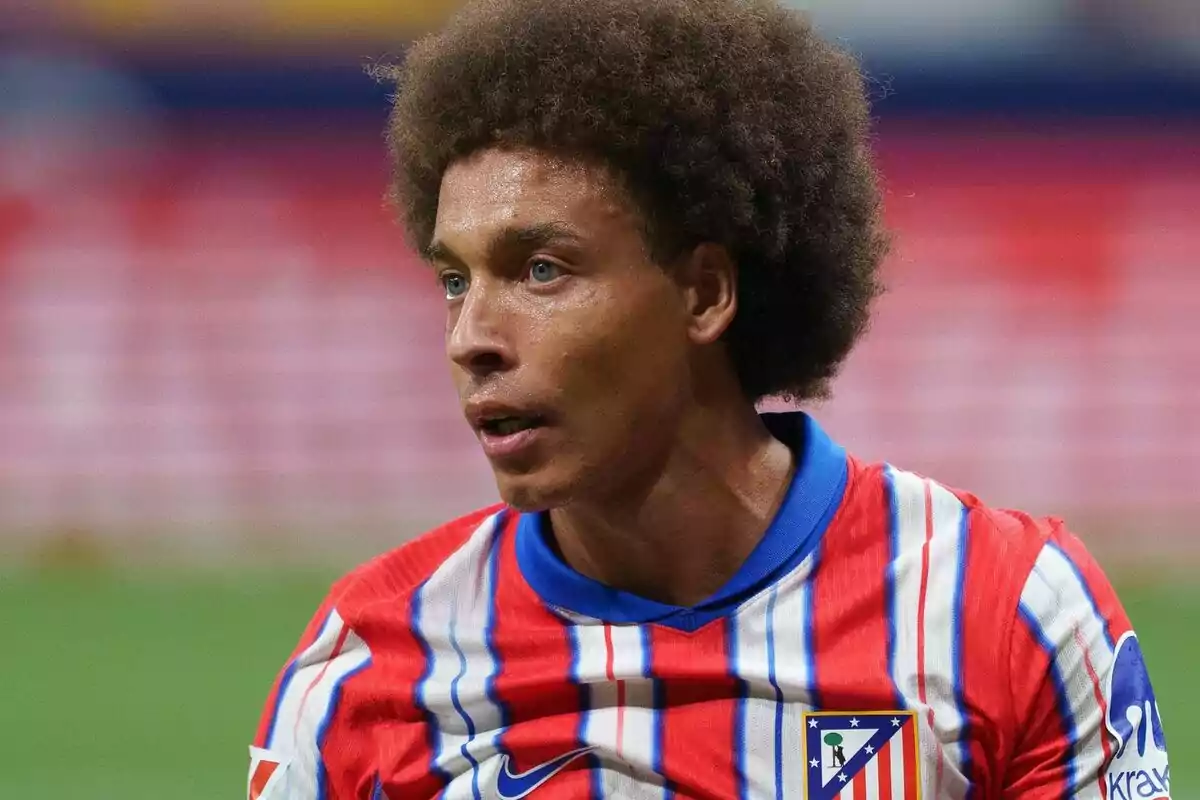 Jugador de fútbol con camiseta del Atlético de Madrid durante un partido.