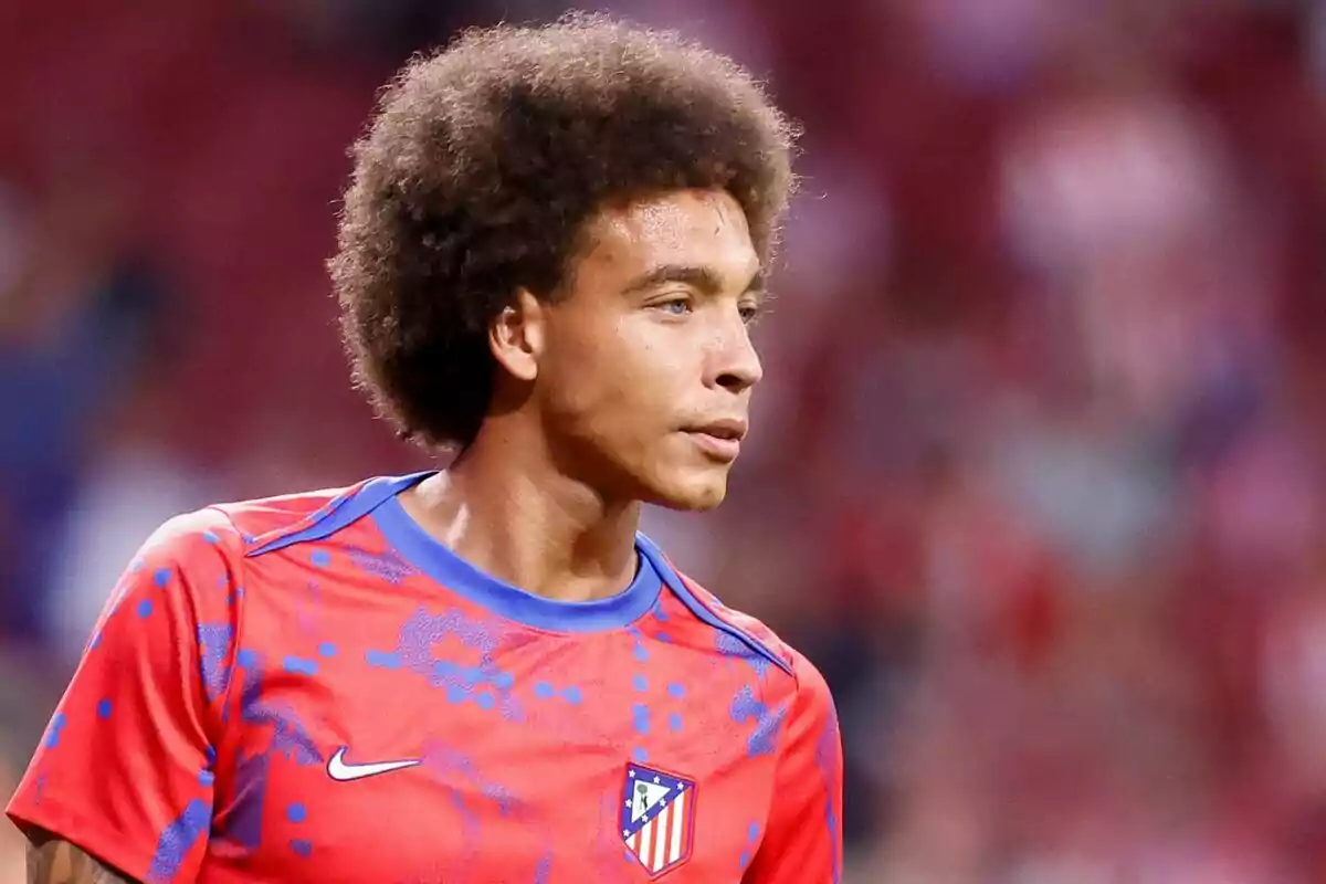 Un jugador de fútbol con una camiseta de entrenamiento roja del Atlético de Madrid.