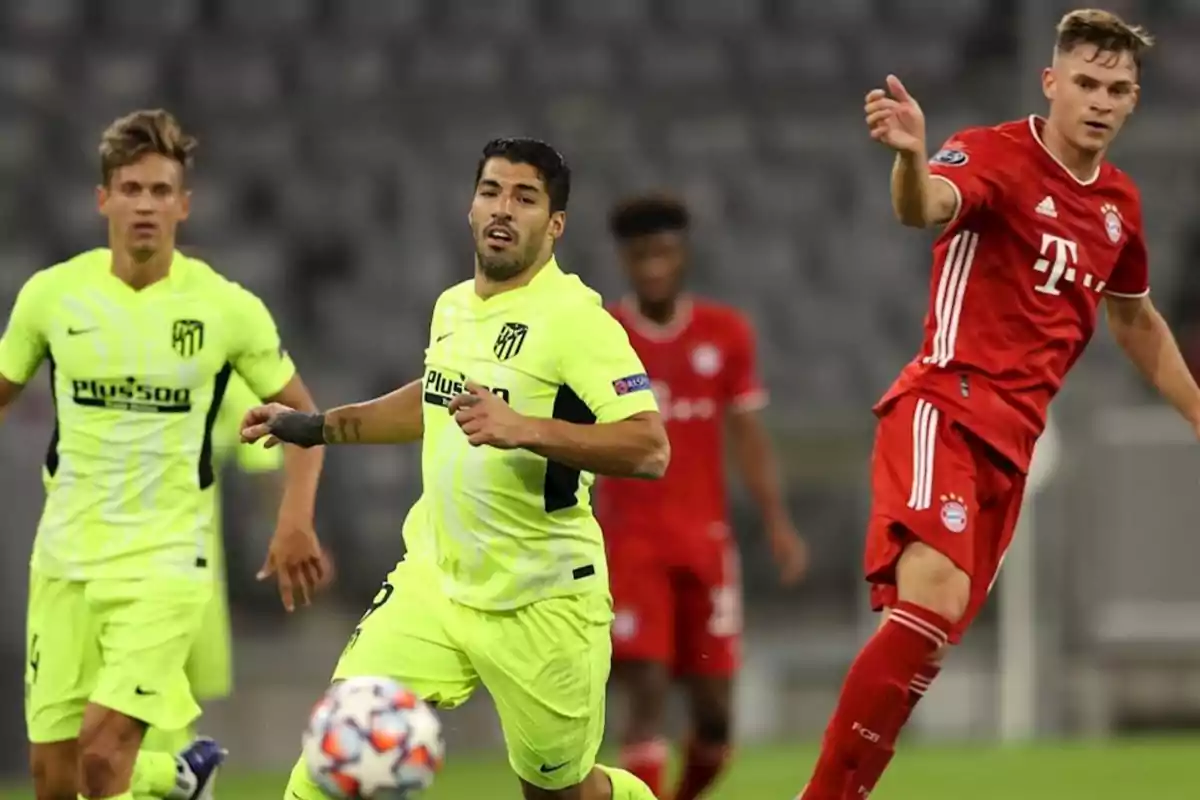 Football players in action during a match between teams wearing red and fluorescent yellow uniforms.