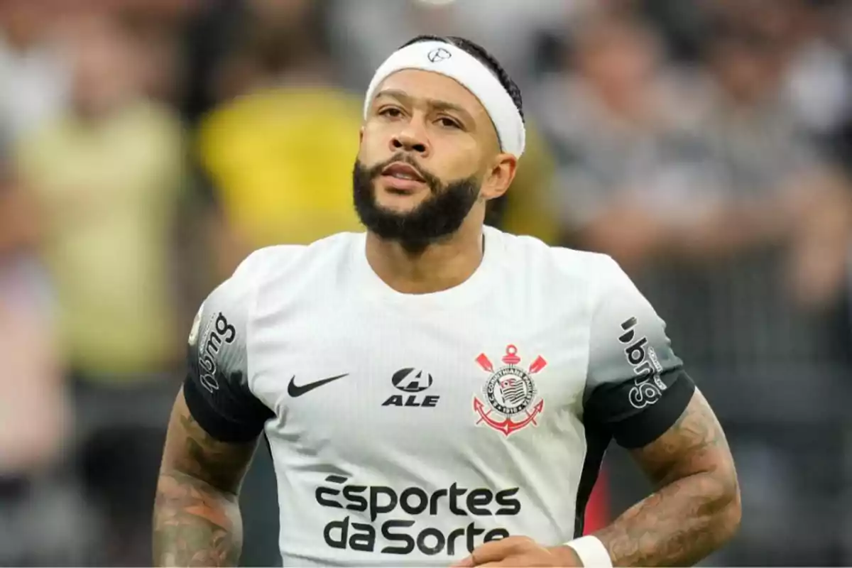 Jugador de fútbol con camiseta blanca del Corinthians y cinta en la cabeza durante un partido.