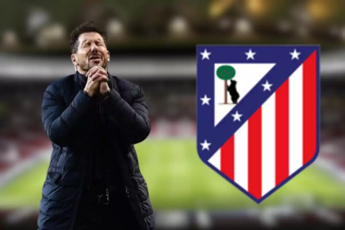 Un hombre con expresión de emoción frente al escudo del Atlético de Madrid en un estadio.