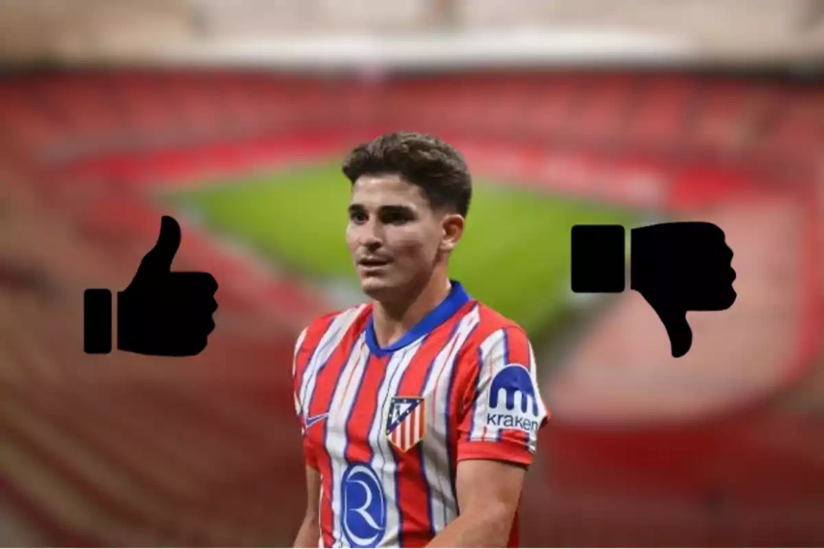 Un jugador de fútbol con la camiseta del Atlético de Madrid, con un pulgar hacia arriba a la izquierda y un pulgar hacia abajo a la derecha, en un estadio desenfocado.