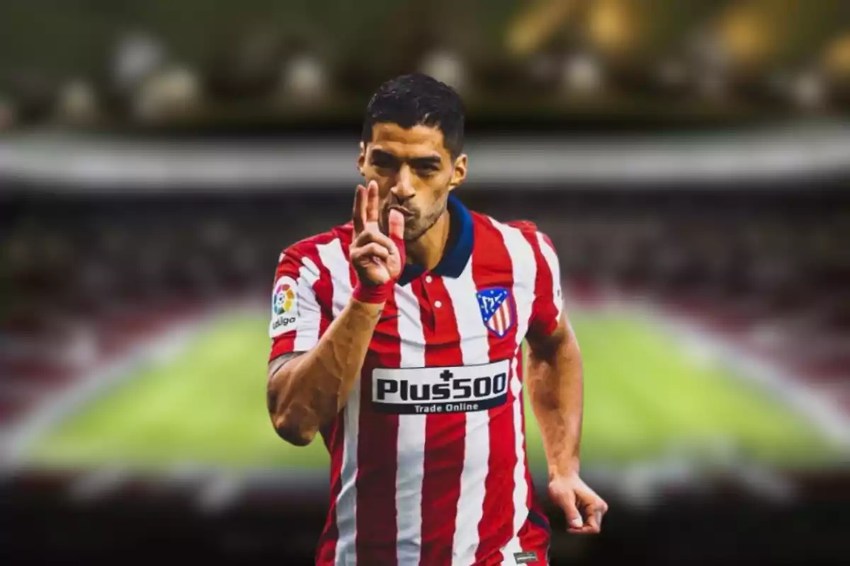 Jugador de fútbol con uniforme del Atlético de Madrid celebrando en un estadio.