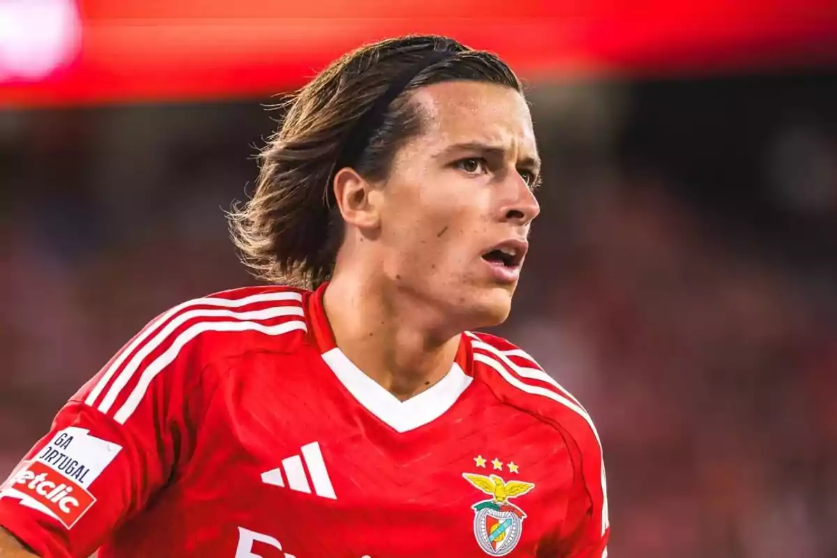 Jugador de fútbol con camiseta roja del Benfica en el campo.