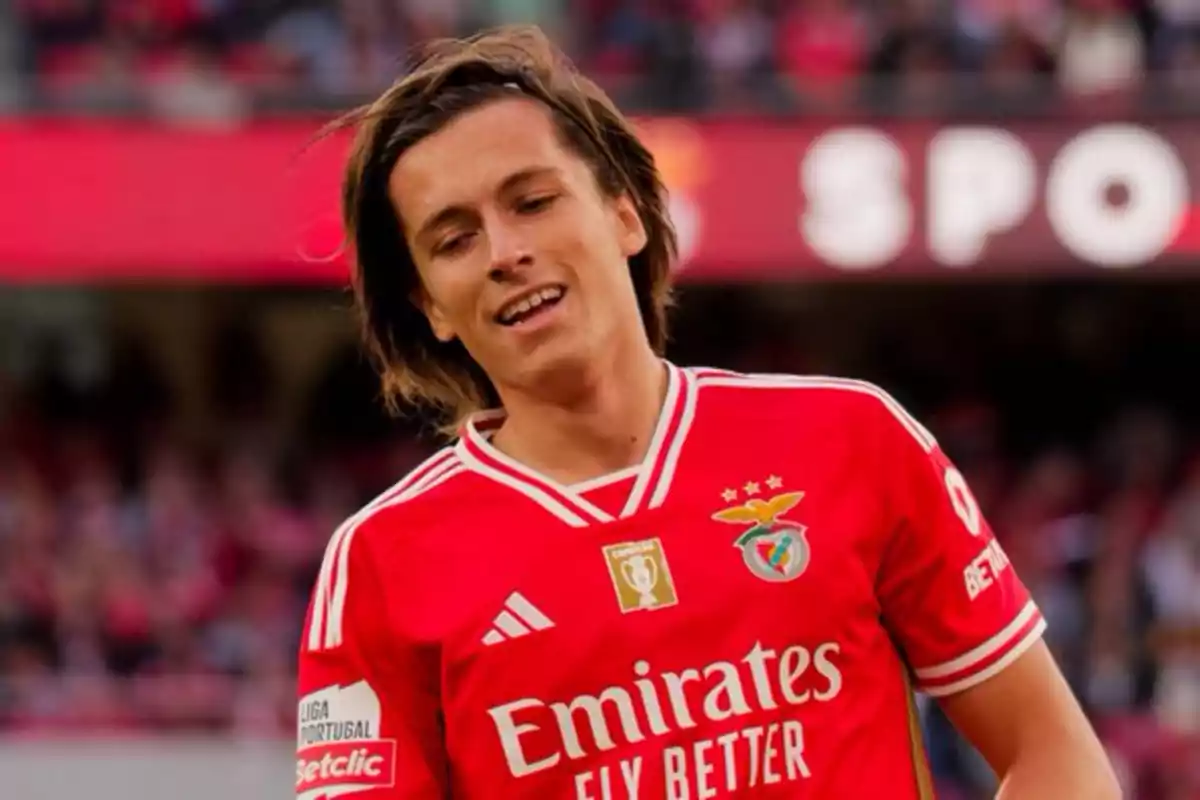 Jugador de fútbol con camiseta roja del Benfica en el campo.