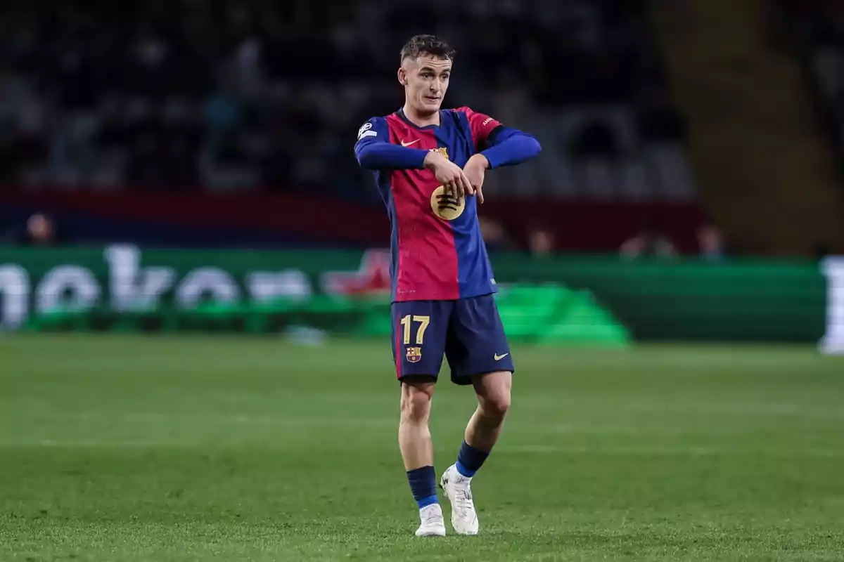 Un jugador de fútbol en el campo con el uniforme del FC Barcelona haciendo un gesto con las manos. Un jugador de fútbol en el campo con el uniforme del FC Barcelona haciendo un gesto con las manos.
