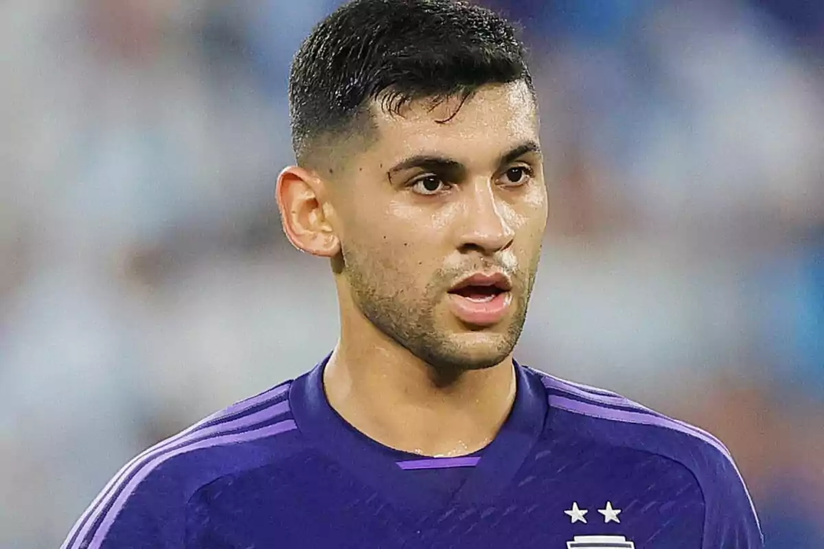 Un jugador de fútbol con camiseta morada durante un partido.