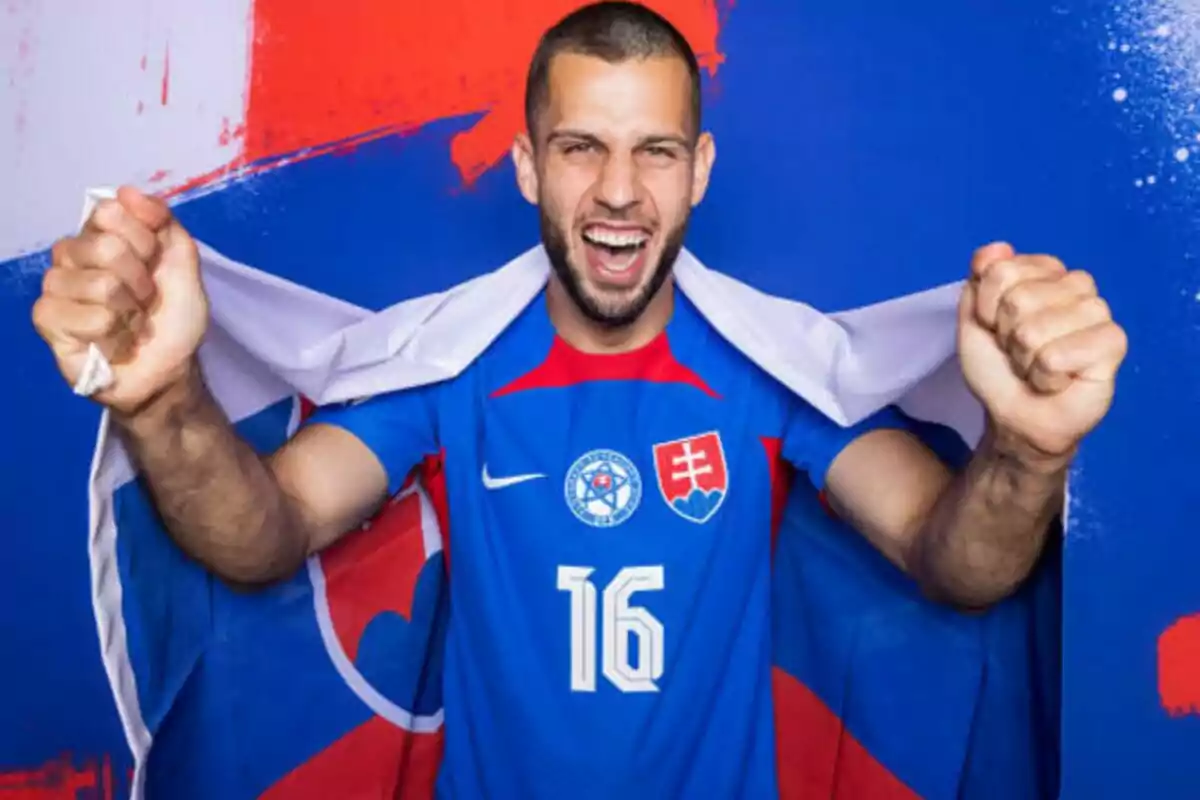 Un jugador de fútbol con la camiseta de la selección de Eslovaquia y el número 16, celebrando con una bandera de su país sobre los hombros.