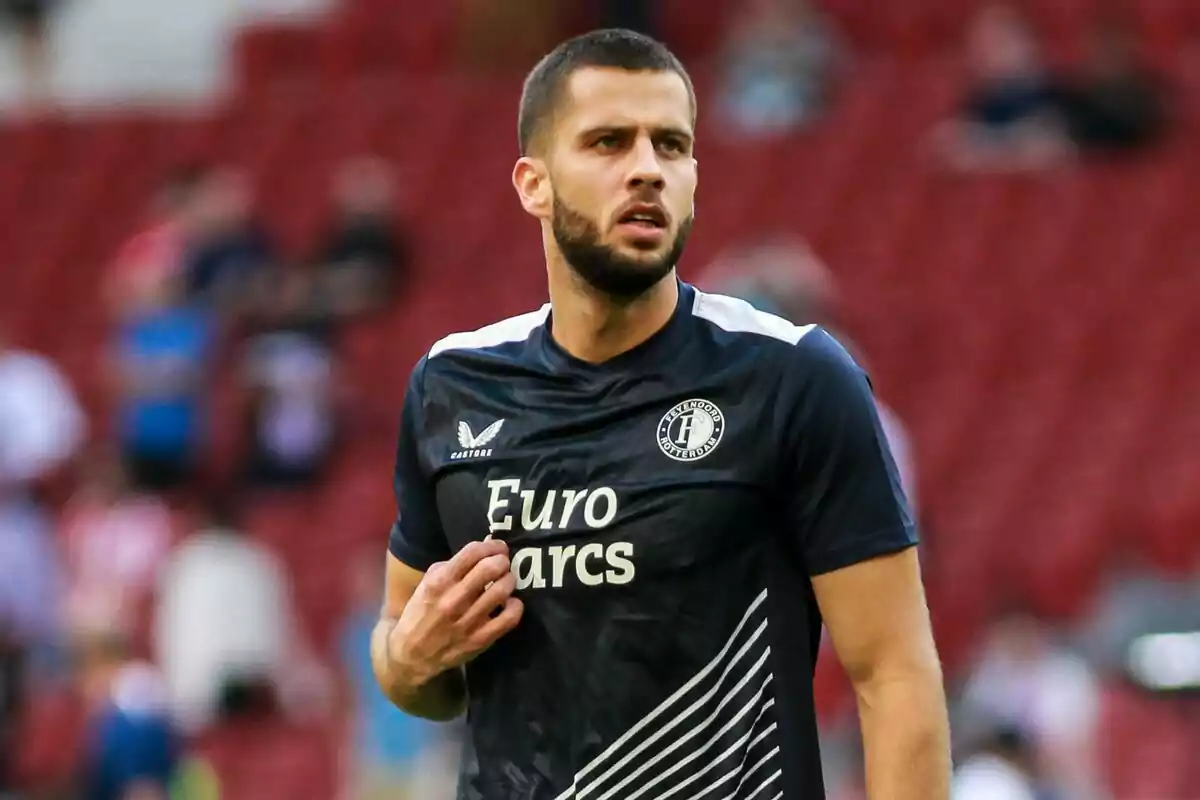 Un jugador de fútbol con barba y cabello corto lleva una camiseta negra del Feyenoord Rotterdam con el logo de Euro Parcs en el pecho.