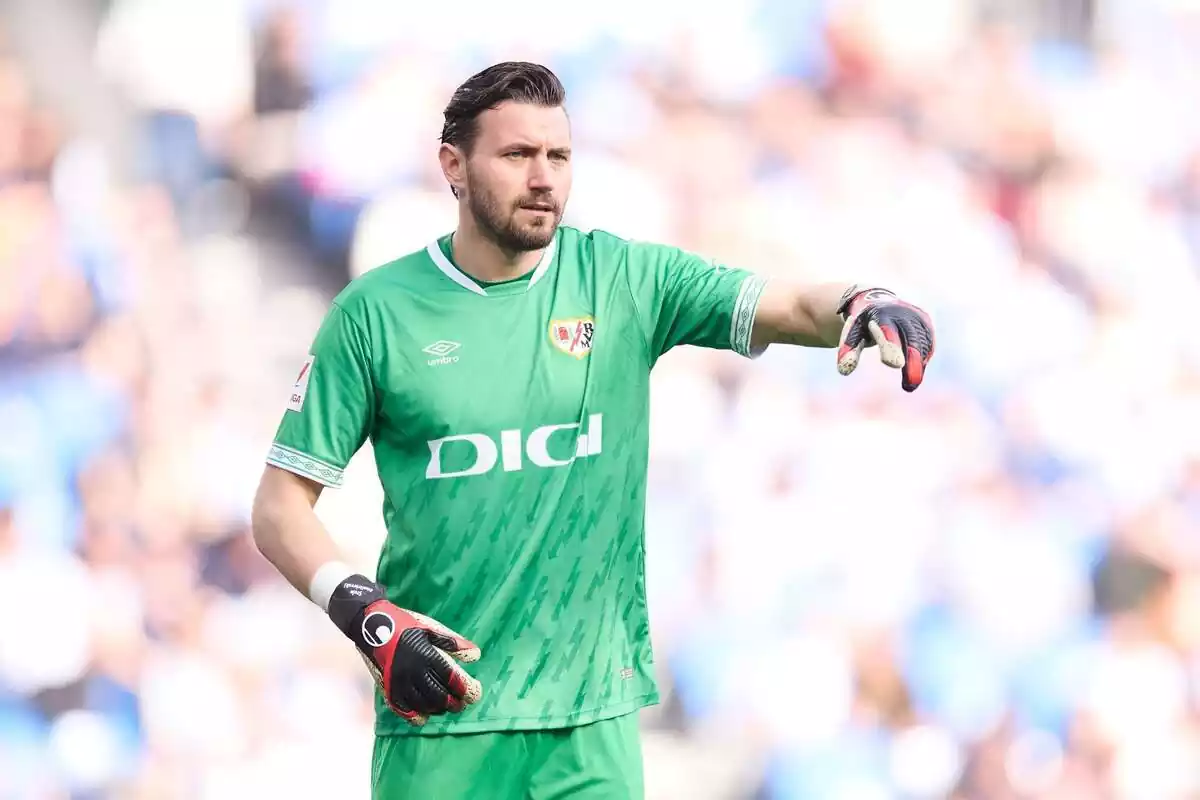 Stole Dimitrievski con la camiseta del Rayo de Vallecano apuntando con la mano hacia delante