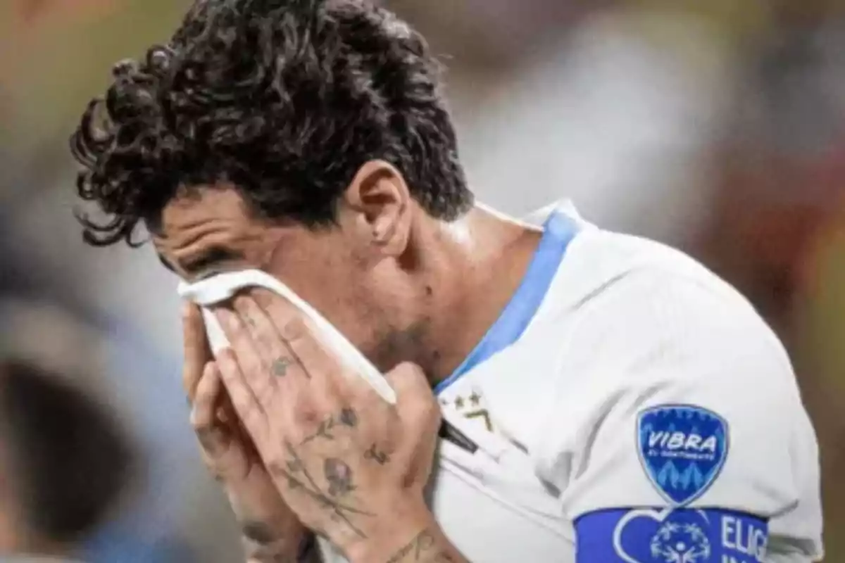 Jugador de fútbol llorando y limpiándose la cara con una toalla