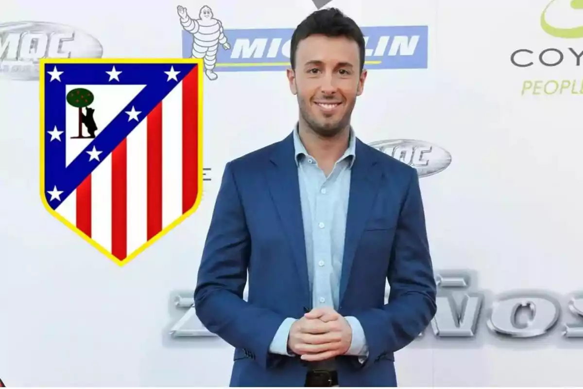 Un hombre con traje azul posando frente a un fondo con logotipos de Michelin y Coyote, junto al escudo del Atlético de Madrid.