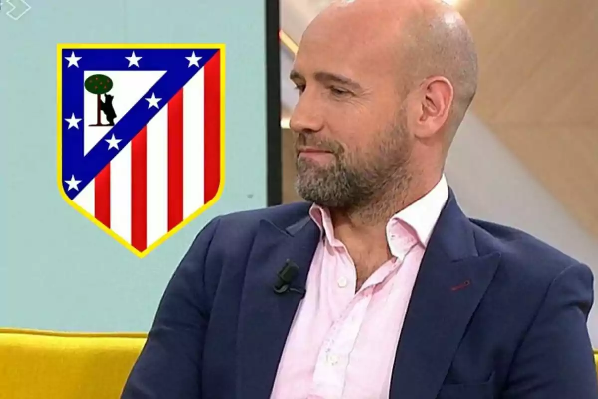 A bald man with a beard, dressed in a pink shirt and a blue jacket, is sitting on a yellow sofa. Next to him, the Atlético de Madrid crest can be seen.