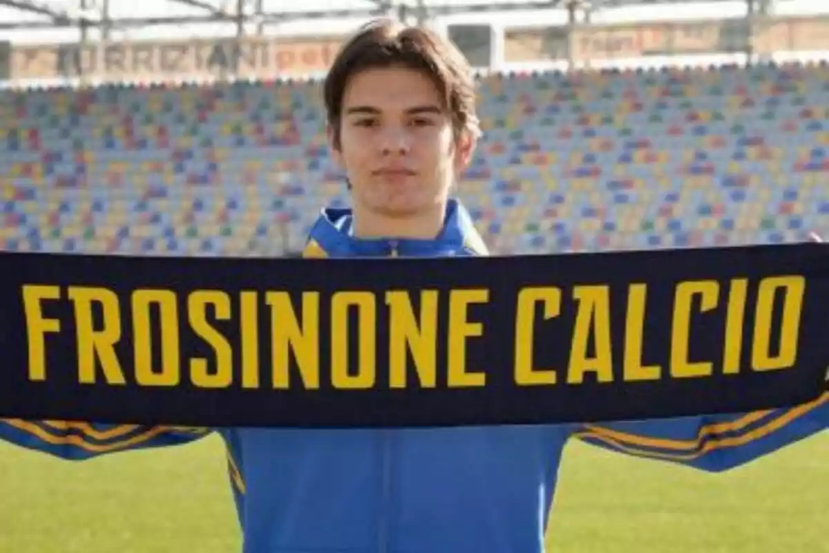 Persona sosteniendo una bufanda del Frosinone Calcio en un estadio.