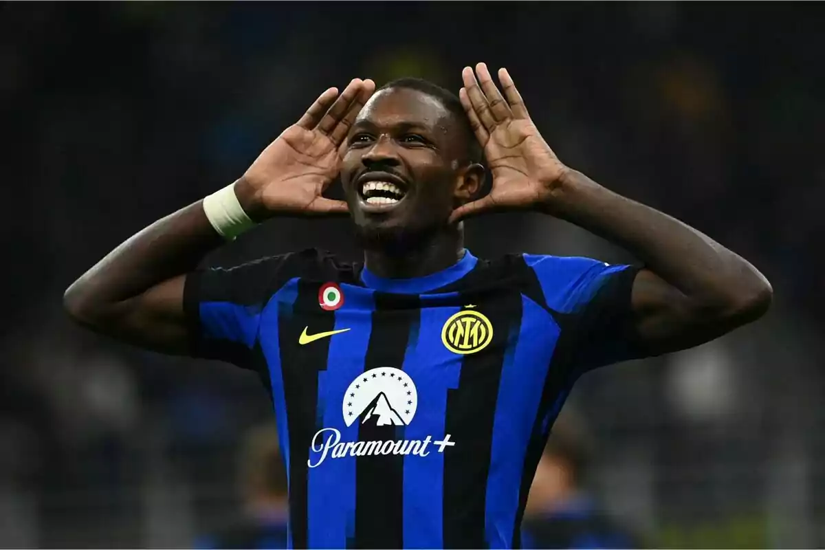 Jugador de fútbol celebrando un gol con las manos en las orejas, vistiendo el uniforme del Inter de Milán.