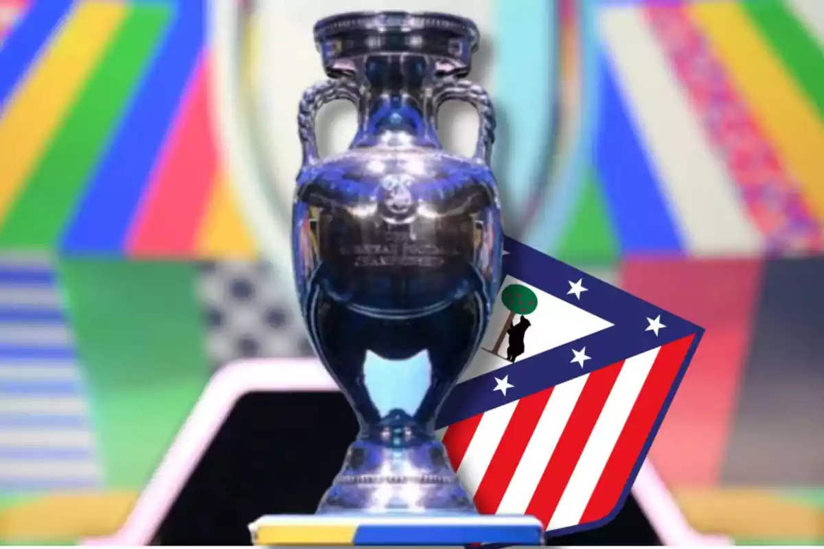 Trofeo de la Eurocopa con el escudo del Atlético de Madrid en el fondo.