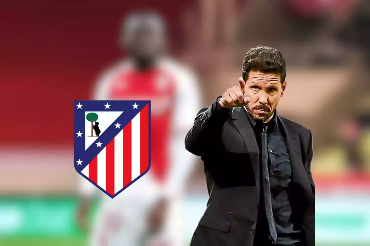 Entrenador de fútbol señalando con el dedo, con el escudo del Atlético de Madrid al fondo.