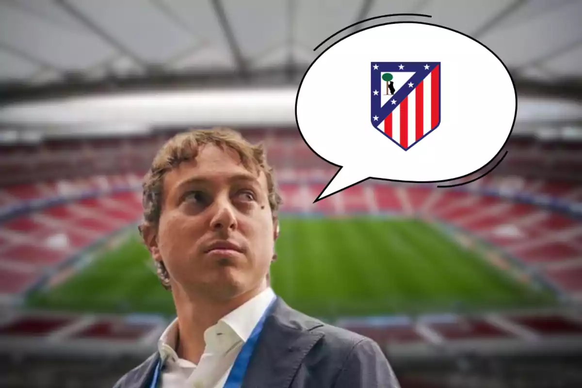 Un hombre con traje y corbata está en un estadio de fútbol vacío, mirando hacia un lado, con un globo de diálogo que contiene el escudo del Atlético de Madrid.