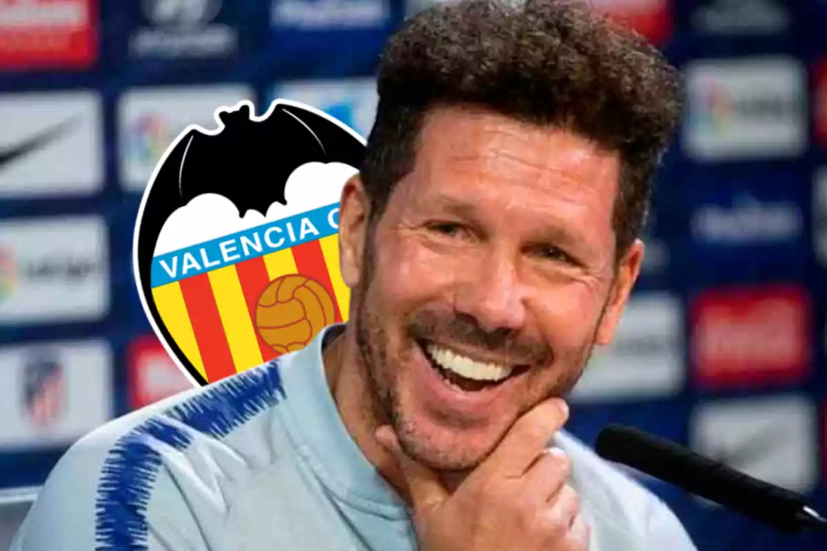 Hombre sonriendo con el logo del Valencia CF de fondo.