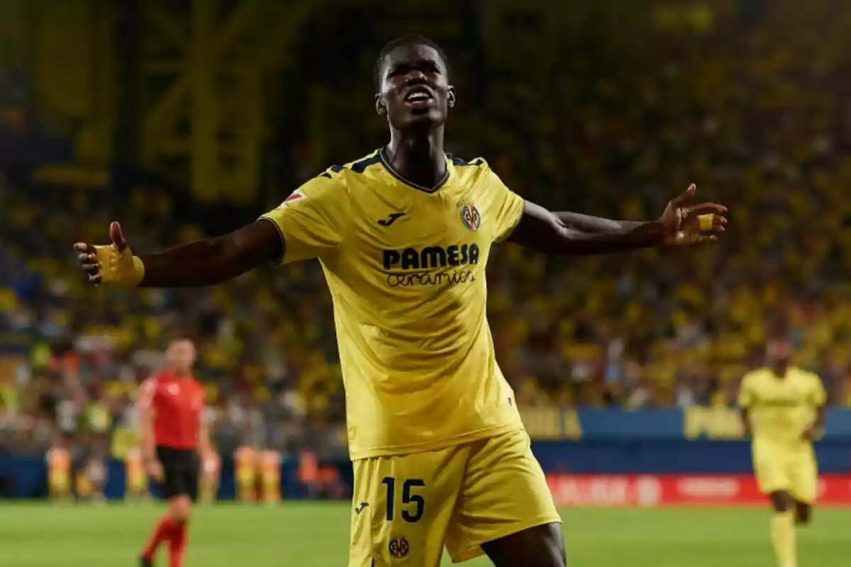 Villarreal football player celebrating on the pitch with his arms outstretched.