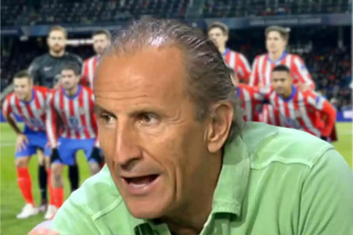 A man in a green jersey speaks while a soccer team in red and white striped uniforms poses in the background.