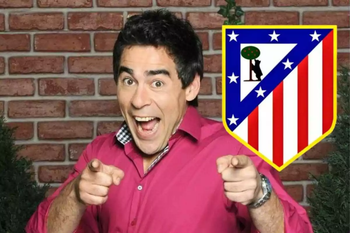 Hombre sonriente con camisa rosa apuntando hacia adelante, junto a un escudo del Atlético de Madrid sobre un fondo de ladrillos.