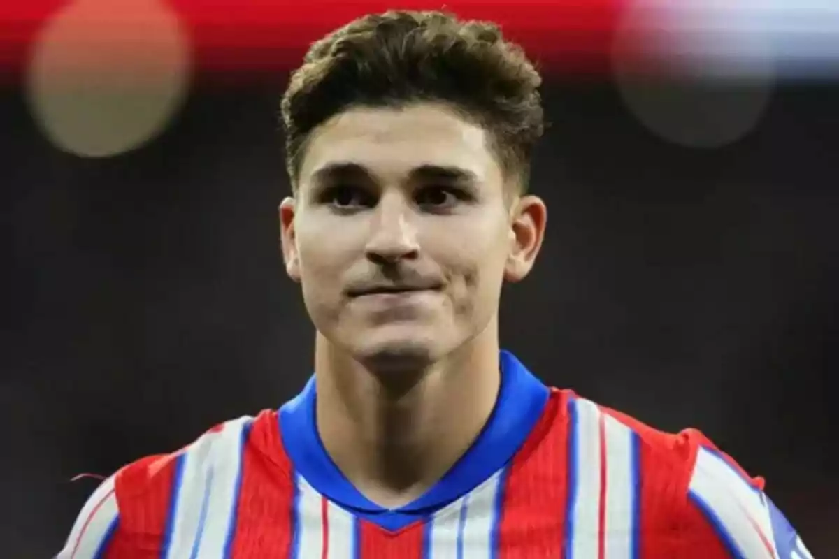 Un jugador de fútbol con camiseta a rayas rojas y blancas.