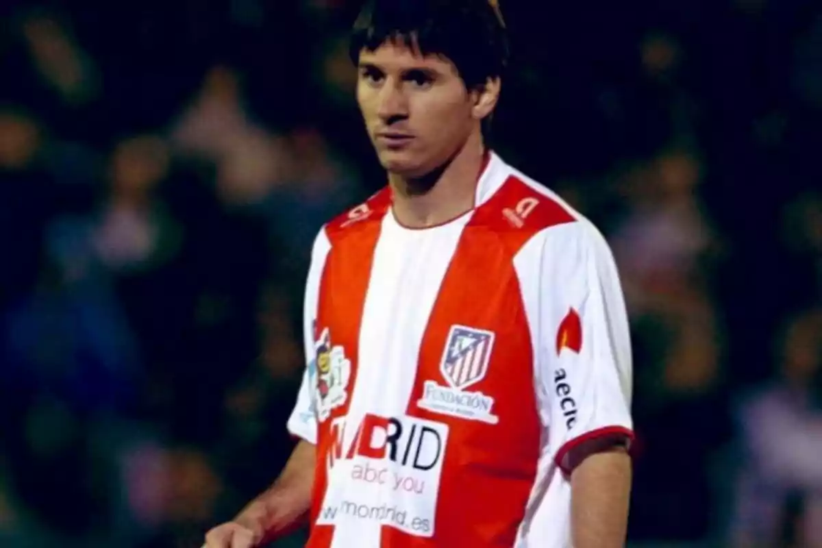 Un jugador de fútbol con una camiseta roja y blanca en el campo.