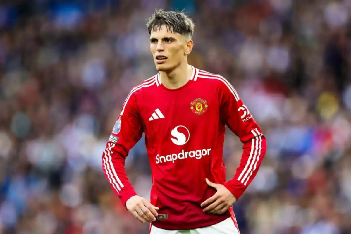 Un jugador de fútbol con el uniforme rojo del Manchester United en el campo.