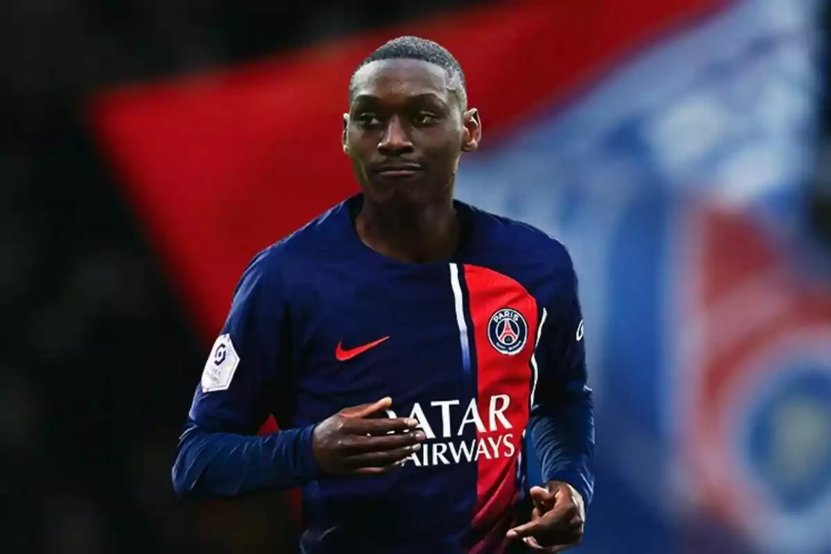 Jugador de fútbol con uniforme del Paris Saint-Germain en el campo de juego.