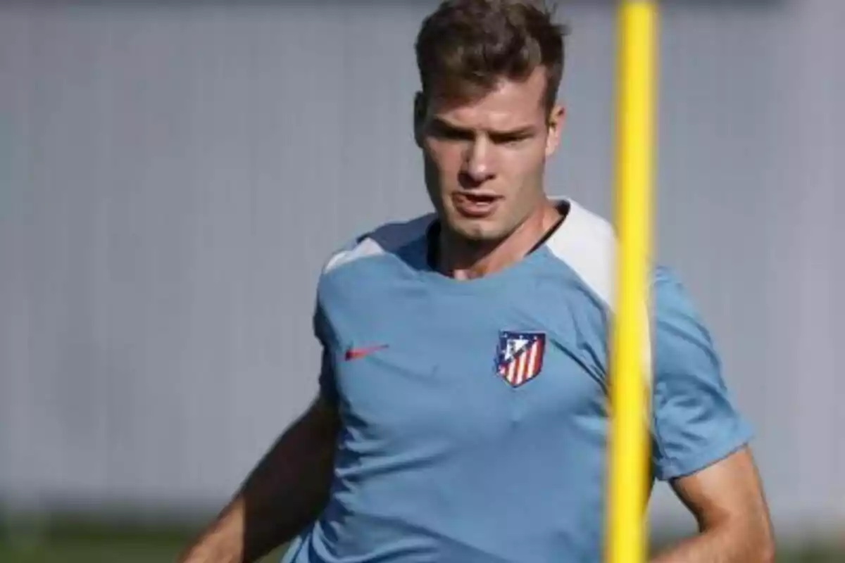 Un jugador de fútbol con una camiseta de entrenamiento del Atlético de Madrid.