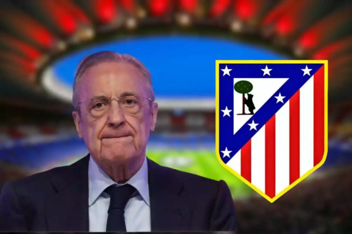 Un hombre con gafas y traje frente a un estadio de fútbol con el escudo del Atlético de Madrid al lado.