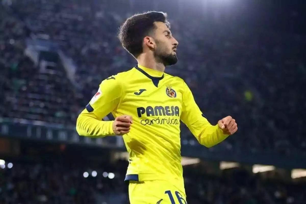 Jugador de fútbol con uniforme amarillo en un estadio.