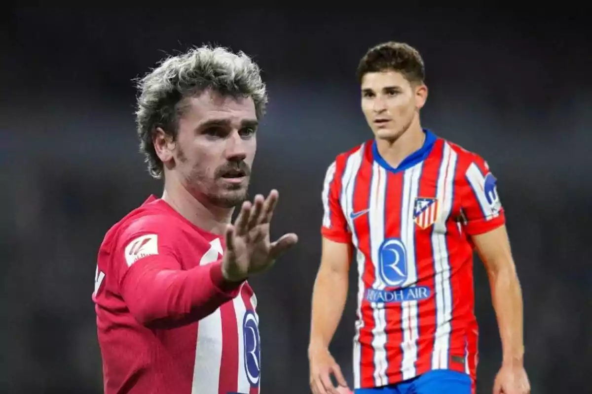 Dos jugadores de fútbol con el uniforme del Atlético de Madrid, uno de ellos con la mano levantada.