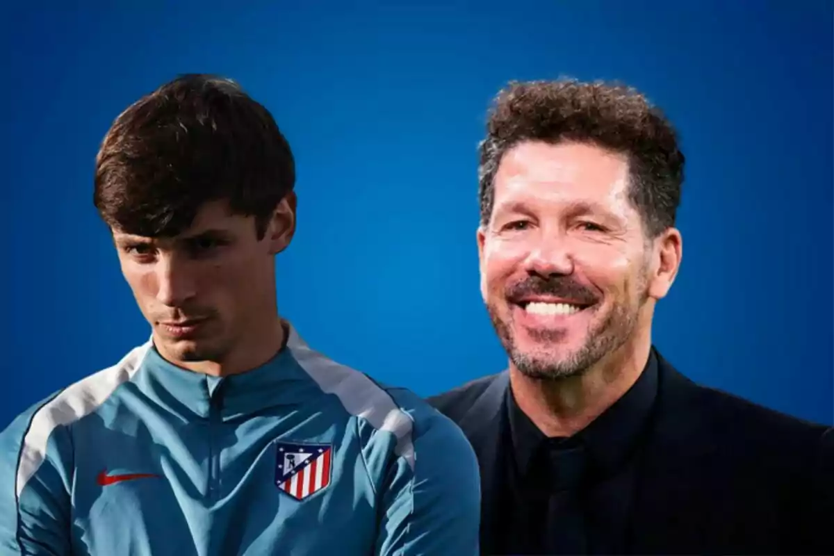 Two men pose in front of a blue background, one wearing an Atlético de Madrid sports jacket and the other wearing a dark suit.