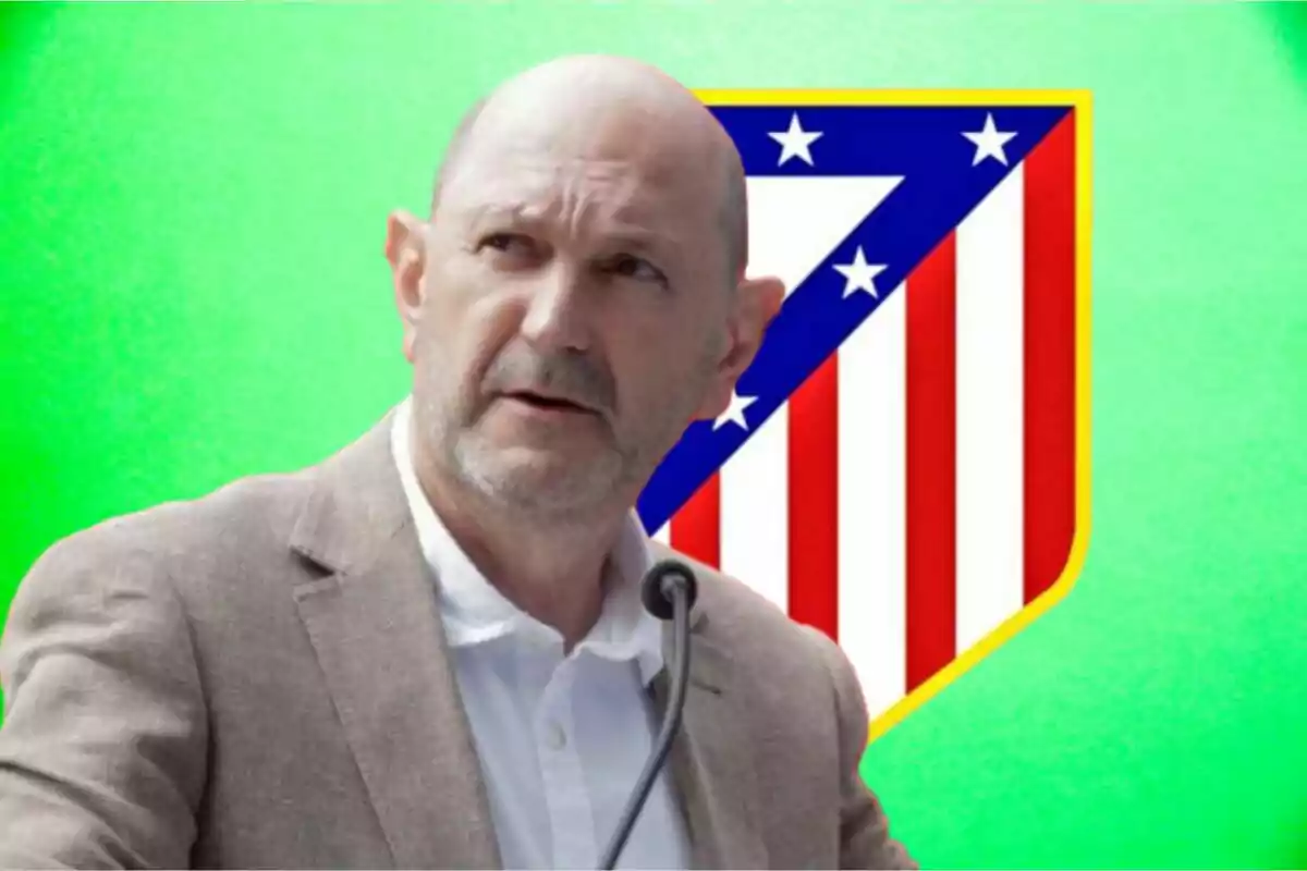 Un hombre con chaqueta clara y camisa blanca frente a un micrófono con el escudo del Atlético de Madrid de fondo sobre un fondo verde.