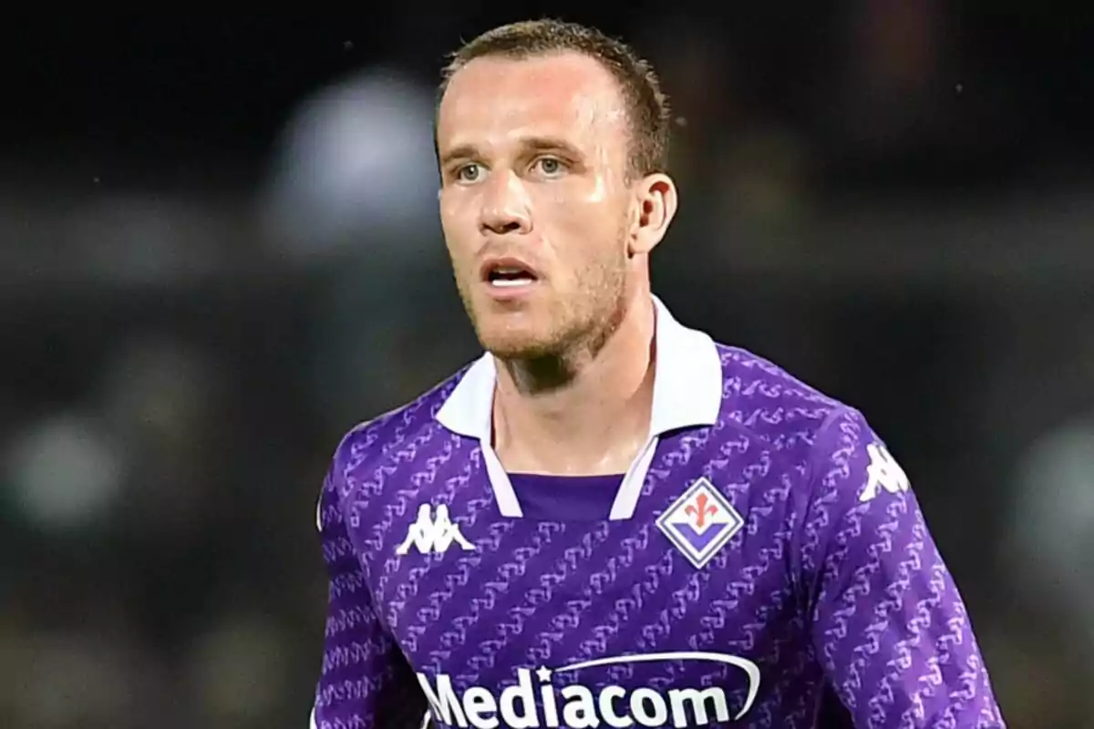 Jugador de fútbol con camiseta morada durante un partido.