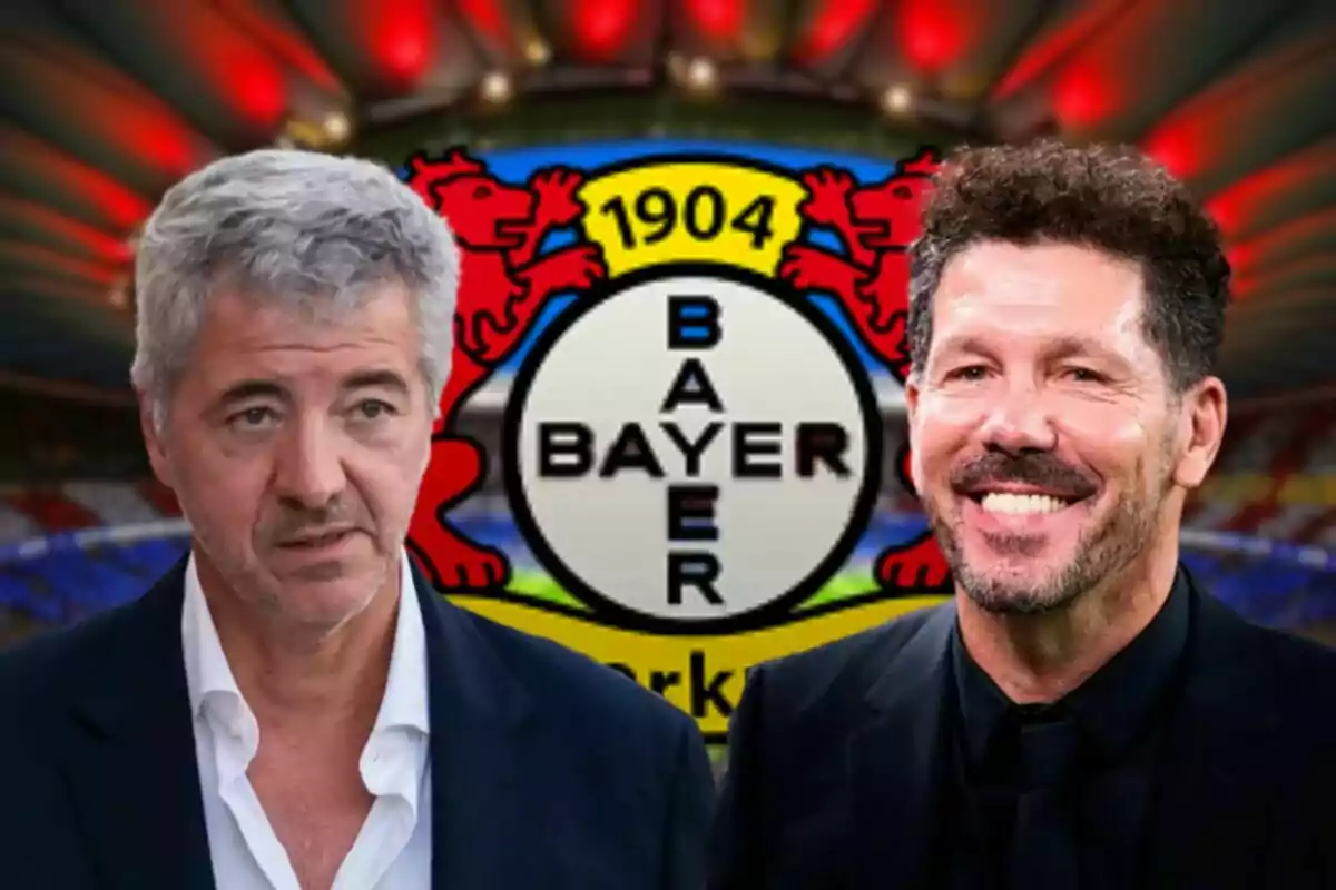 Dos hombres con traje frente al logo del Bayer Leverkusen en un estadio iluminado.