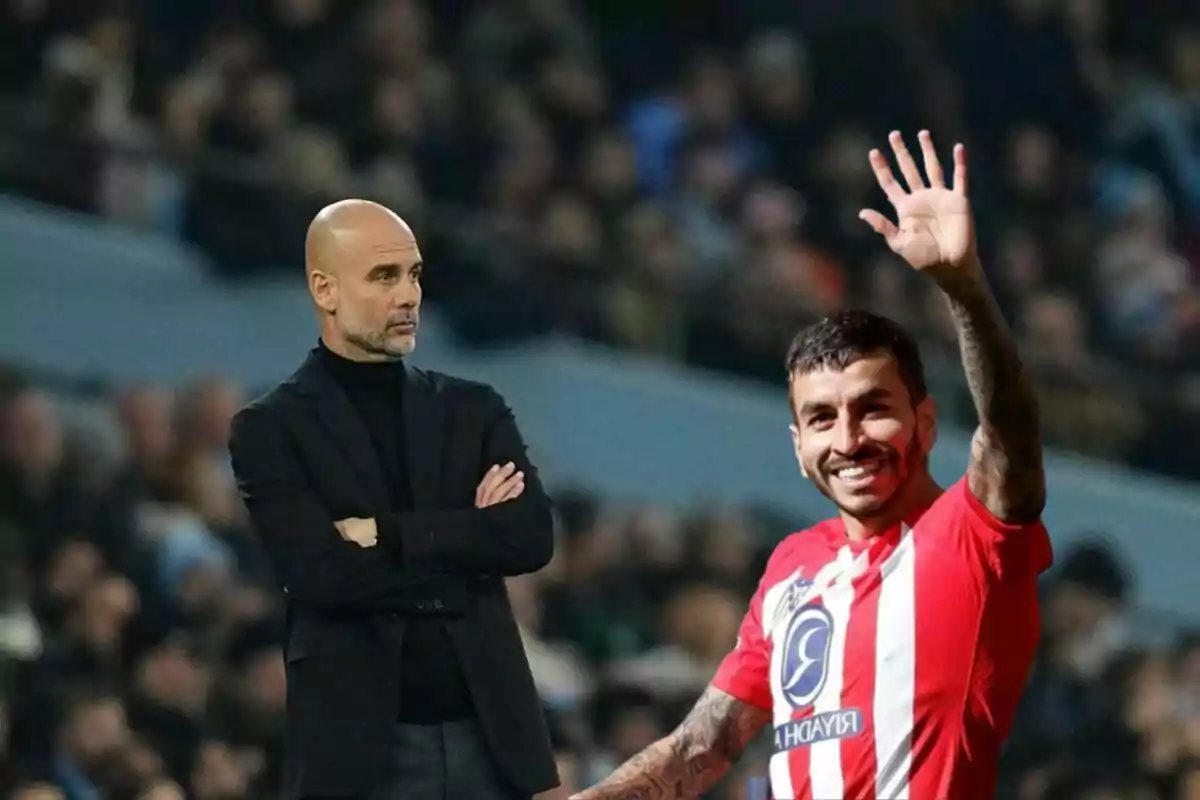 Un entrenador de fútbol observa con los brazos cruzados mientras un jugador sonriente y con uniforme rojo y blanco saluda al público.