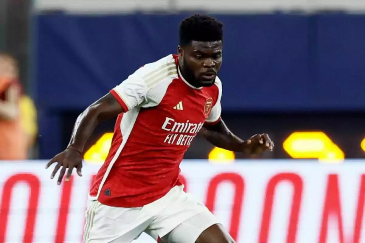 Un jugador de fútbol del Arsenal con uniforme rojo y blanco en acción durante un partido.