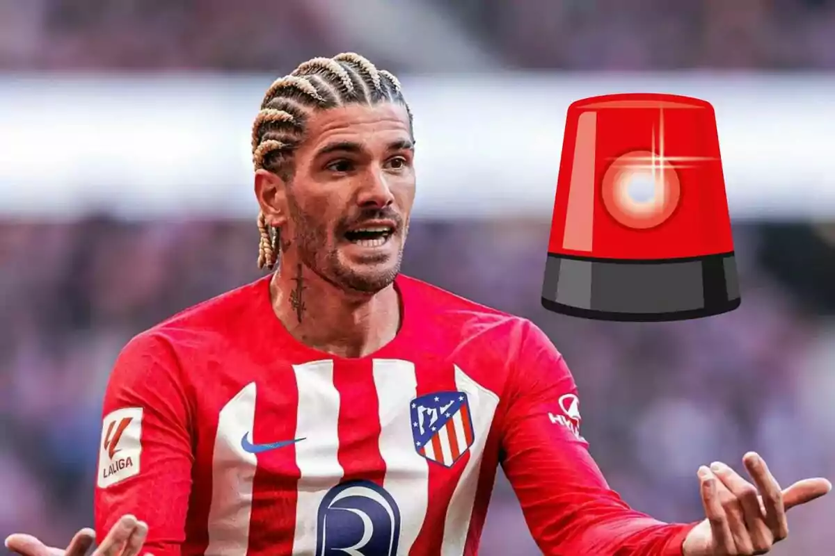 Un jugador de fútbol con trenzas rubias y camiseta roja y blanca del Atlético de Madrid gesticula con las manos mientras una sirena roja de alerta está superpuesta a su lado.