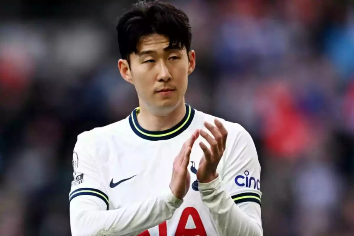 Football player applauding in Tottenham Hotspur shirt.