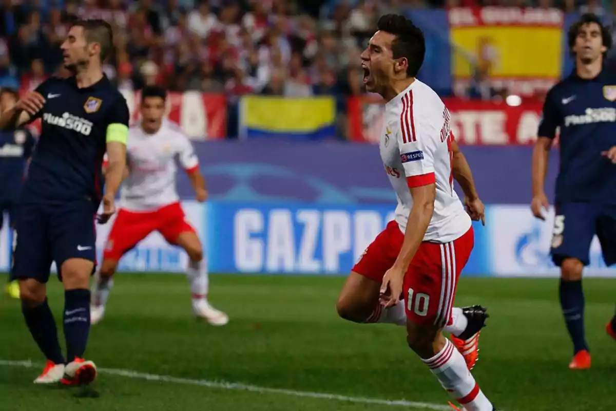 Football players in action during a match, one of them celebrating a goal.