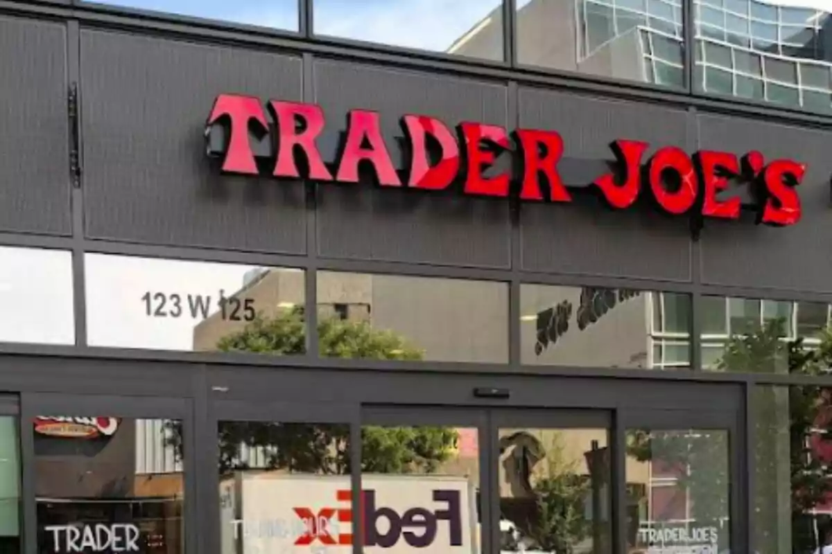 Fachada de una tienda Trader Joe's con letrero rojo y ventanas de vidrio. Fachada de una tienda Trader Joe's con letrero rojo y ventanas de vidrio.