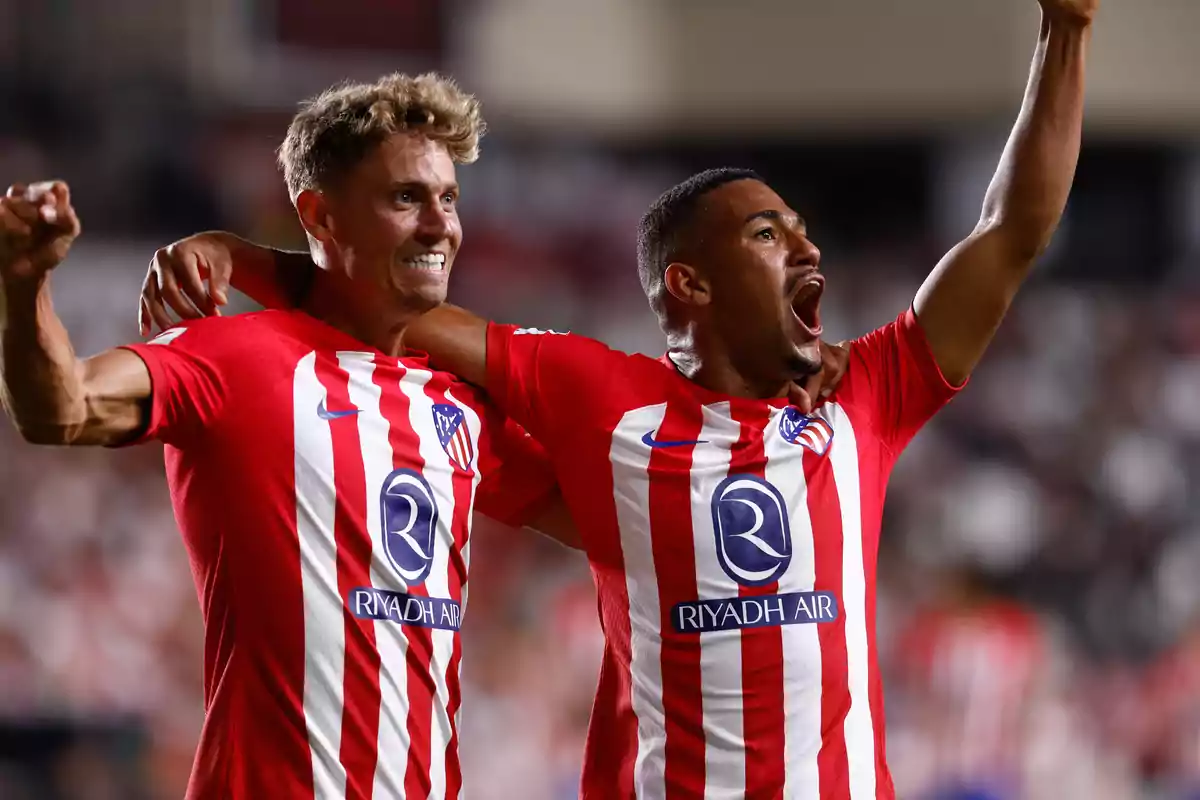 Dos jugadores de fútbol celebrando un gol con camisetas del Atlético de Madrid.