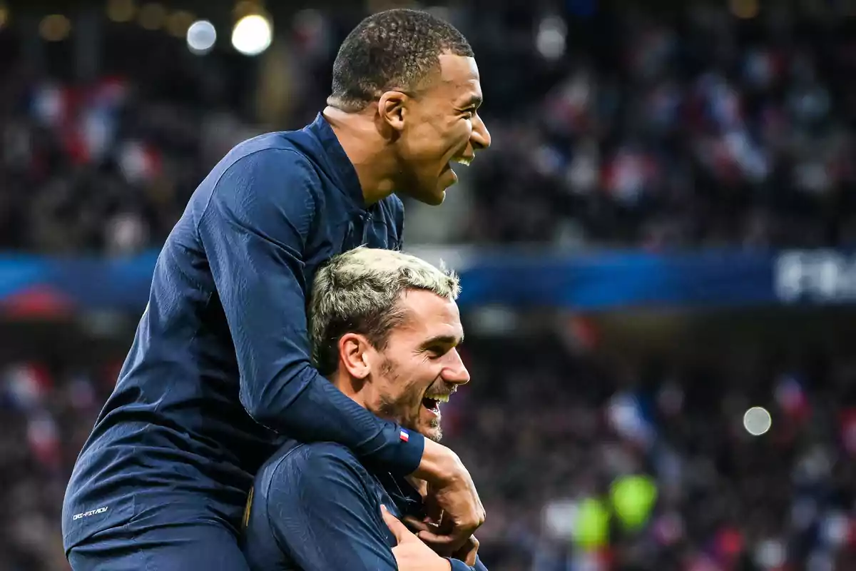 Dos jugadores de fútbol celebrando un gol en el campo.