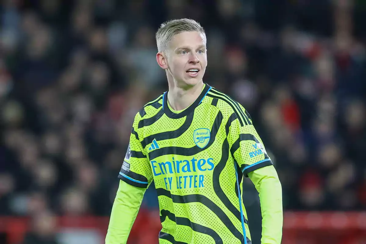 Un jugador de fútbol con el uniforme del Arsenal en un campo de juego.