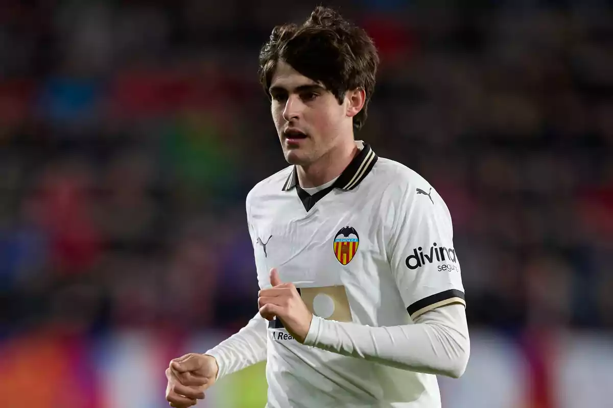 Un jugador de fútbol con el uniforme del Valencia CF en el campo.