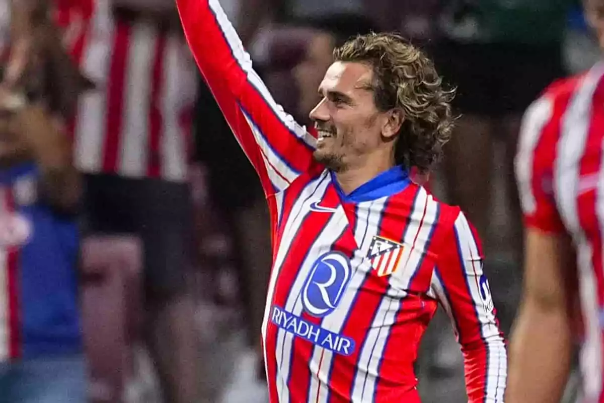 Jugador de fútbol con uniforme rojo y blanco celebrando en el campo.