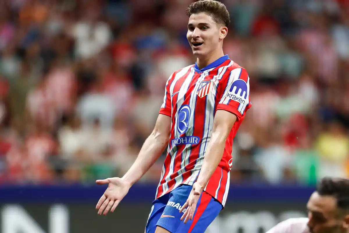 Soccer player in red and white striped uniform in a stadium.